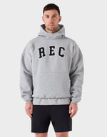 Man wearing a gray hoodie with 'REC' printed on it against a white background